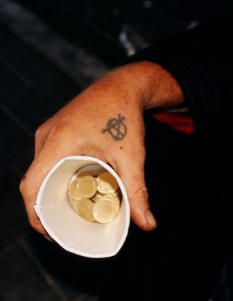 Hand mit Pappbecher und Münzen drin - Quelle: Wikipedia